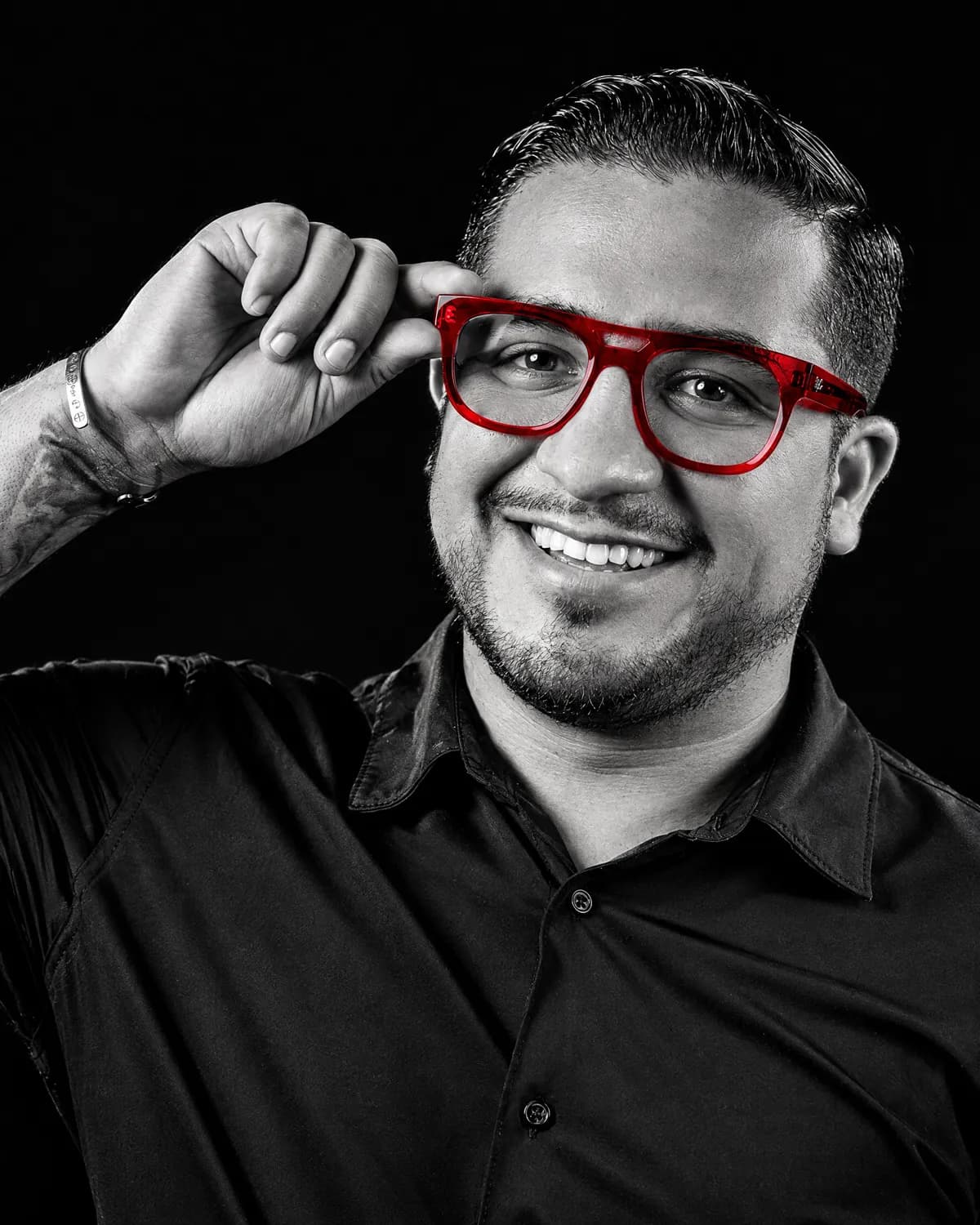 Rik Landeros hoy, sonriendo con sus lentes rojos